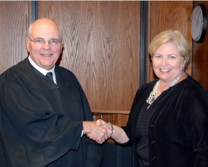 Superior Court Judge Henry W. "Chip" Hight, left, congratulates business owner Michele Eaves Burgess of Henderson, right, after swearing her in to serve a four-year term on the VGCC Board of Trustees.