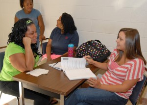 In the foreground, Ashley Woods (left) talks with Megan Sullivan, while in back, Aqueria Hargrove (standing) talks with Imani Guy, as they participate in scenarios in which they practice interviewing and hiring staff for an afterschool program. (VGCC photo)