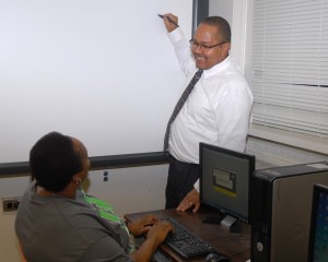 Elsie Gray of Henderson (seated) talks with VGCC instructor Donald Evans in the classroom at Western Vance High School. (VGCC photo)