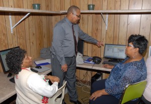 Students Magnolia Jackson (left) and Alice Burroughs (right), both of Manson, listen as VGCC instructor Donald Evans (center) explains a computer skills test at St. Delight Holy Church. (VGCC photo)