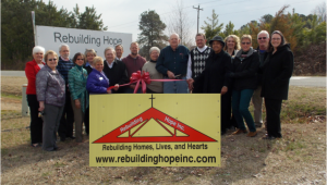 Shown at the Henderson-Vance Chamber of Commerce ribbon cutting for Rebuilding Hope, Inc. are (Left to Right), Nancy Gray, United Way; Jenny Hester, Prim Development and HVCC Board Chair; Chamber Ambassador Clareese Moss, New You with Shortcake; Mike Rainey, City Tire & Mayor Pro Tem; Gail Wilson, Rebuilding Hope; Randolph Wilson, Rebuilding Hope Founder & Director; Rev. Larry McElreath, Cullom Baptist Association; Deborah Brown, Chair, Vance County Board of Commissioners; Pam Norwood, Magnolia Management; Melanie Mann, HVCC Office Manager; Second row: Jennifer Sawyer, United Way; Chamber Ambassador Michael Bobbitt; Sheri Jones, HVCC Communications Consultant; John Barnes, HVCC President; Steve Cannon, Rebuilding Hope; Chamber Ambassador Holly Nix, Henderson Wellness Center; Tony Norwood, Magnolia Management. Not pictured: Annette Roberson, Director of Membership Services.
