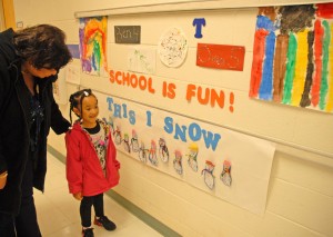 Four-year-old VGCC Child Care Center student Mya Thompson of Henderson (center) shows her mother, Rene Alston-Thompson, the artwork that she and her classmates created. (VGCC photo)