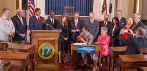 Photo of bill signing from the Governor's Office website.