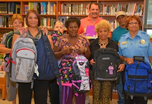 VGCC Warren Campus faculty and staff hold some of the book bags donated to J-Jireh Services; in front, from left, campus coordinator/Warren Early College liaison Faye Goode, J-Jireh director Gertie Williams Crute, Basic Skills coordinator/instructor Edna Scott and security officer Helena Jenkins; and in back, from left, administrative assistant Lisa Rodwell, Office Administration instructor Jessica Harvey, campus Dean Mitch Evans and campus custodian James Burwell. (VGCC photo)