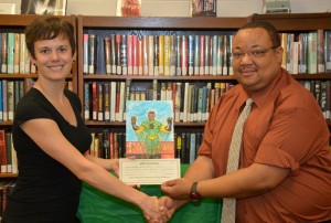 VGCC English instructor Bridget Bell presents a gift certificate on behalf of the Library Services Subcommittee to student Wiley L. Davis of Henderson in the Library on the college’s Main Campus. Between the two is Davis’ winning poster concept. (VGCC photo)