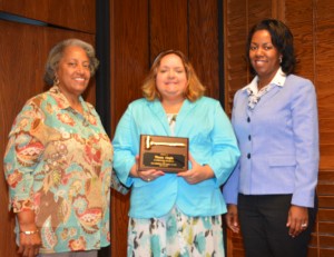 Deborah Brown, left, chair of the Vance-Granville Community College Board of Trustees, and Dr. Stelfanie Williams, right, president of VGCC, present a plaque to Theresa Chiplis, president of the Student Government Association and the student trustee on the trustees board for 2014-2015, at the board’s meeting on May 18. Chiplis, who graduated with her third degree this month, served for two years as student trustee. (VGCC photo)