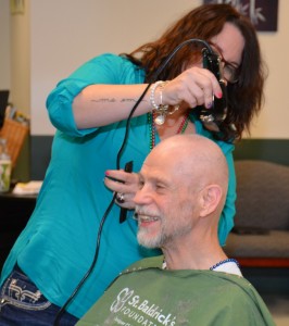 VGCC Cosmetology instructor Emily Ankrom shaves the head of Chris Brockman, who teaches English and Reading at the college. Brockman composed a poem to help encourage donations: “Even if you couldn’t care less / About seeing Brockman’s head hairless / Help the search for cancer’s cure / So all our kids can live secure.” (VGCC photo)