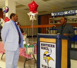 Superintendent Ronald E. Gregory, left, listens as Archie Taylor reads a proclamation from the Vance County Board of Commissioners.
