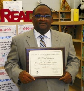 Dr. John Hargrove, principal of Henderson Middle School, holds the plaque he received for his successful completion of the state’s Distinguished Leadership Program for top school administrators.
