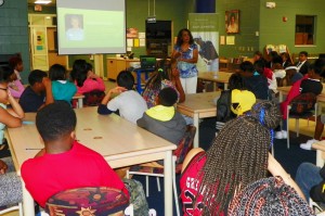 Doneva Chavis-Battle is shown in the center background as she speaks to a group of students at Eaton-Johnson Middle School about the hotel and hospitality industries.