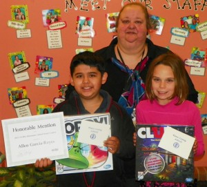 From left, Allen Garcia-Reyes, a fifth grader, and Elizabeth Black, a third grader, both students at Aycock Elementary. Garcia-Reyes also holds the "Honorable Mention" award he received for his poster being recognized at the NCSBA Conference on November 16 in the grades 3-5 category. Pam Barrier, Aycock's art teacher who worked with the students, also is shown.
