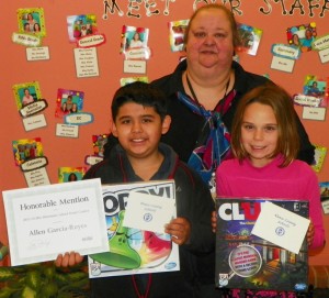 From left, Allen Garcia-Reyes, a fifth grader, and Elizabeth Black, a third grader, both students at Aycock Elementary. Garcia-Reyes also holds the "Honorable Mention" award he received for his poster being recognized at the NCSBA Conference on November 16 in the grades 3-5 category. Pam Barrier, Aycock's art teacher who worked with the students, also is shown. 