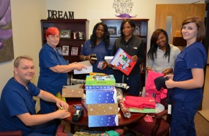 From left, VGCC Cosmetology students and SkillsUSA members Christopher Hendricks of Macon, Daphne Hendricks of Macon, Jessica Brown of Henderson, Kiamesha Alston of Norlina, Keosha Perry of Henderson and Dana Moseley of Norlina wrap Christmas presents for a local family. (VGCC photo)