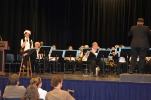 Claire Ramsey of Oxford (seated on stool at left) narrates during the Vance-Granville Community Band performance of “'Twas the Night Before Christmas.” Brian Miller of Louisburg conducts. (VGCC photo)