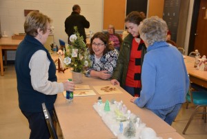 From left, Dianne Moss of Youngsville talks about her artwork with open house attendees Alice Lopez and Lauralee Lopez, both of Youngsville, and Bertie Bumgarner, a northern Franklin County resident. Moss teaches a China painting course at VGCC’s Franklin County Campus.  Bumgarner teaches a class on ceramics and porcelain dollmaking, which also encompasses arts such as figurine painting and melted glass bottles. (VGCC photo)