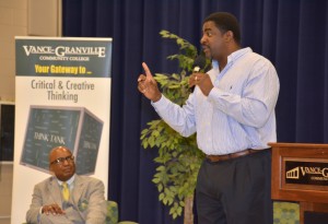 Greg Ellis (standing) makes a point during his remarks at VGCC, as his middle school coach, VGCC’s Anthony Pope (seated), listens. (VGCC photo)