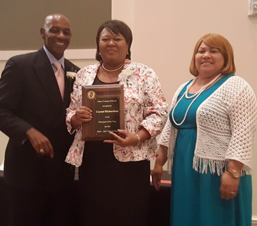 Crystal Richardson of Clarke Elementary School, center, accepts the 2016-2017 VCS Principal of the Year plaque from Jackson and White.