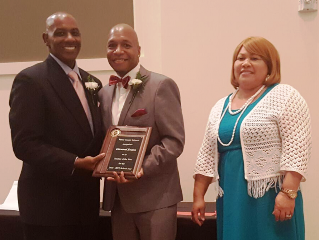 Linwood Swann of Eaton-Johnson Middle School, center, accepts the 2016-2017 VCS Teacher of the Year plaque from Superintendent Anthony D. Jackson and Board Chair Gloria J. White.